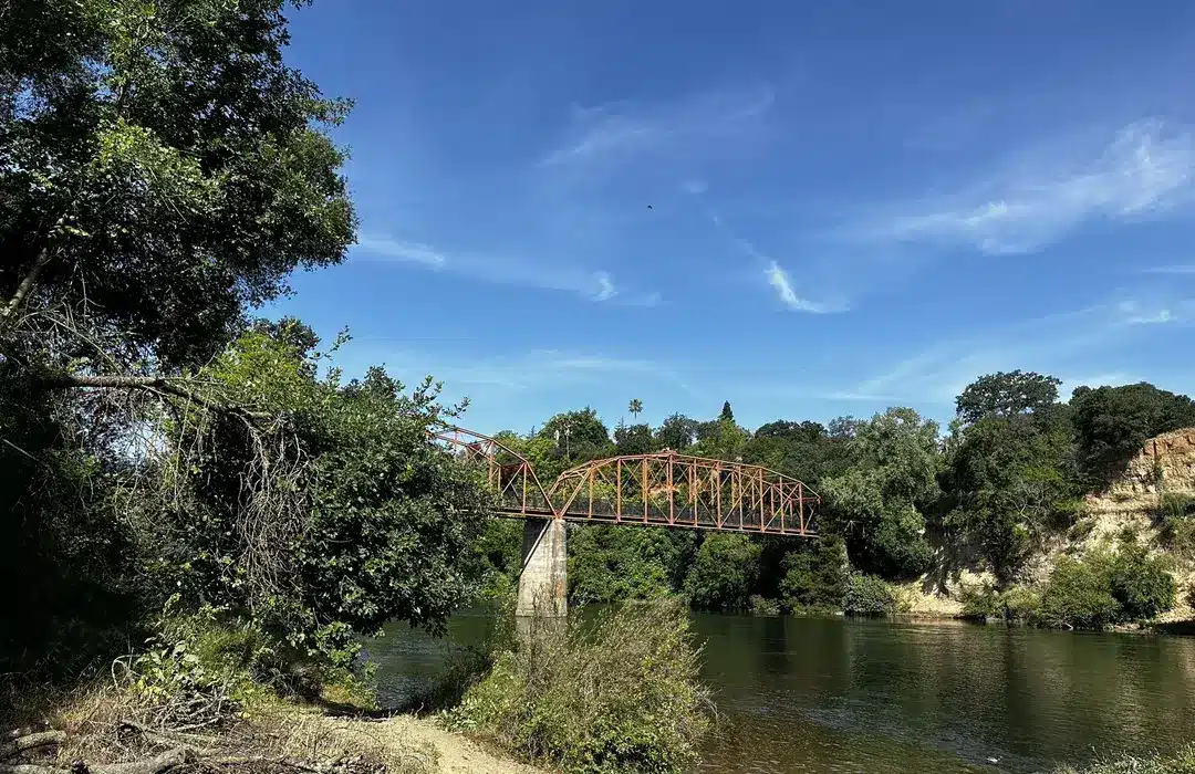 Rustic bridge over the American River near Orangevale, CA surrounded by trees and nature