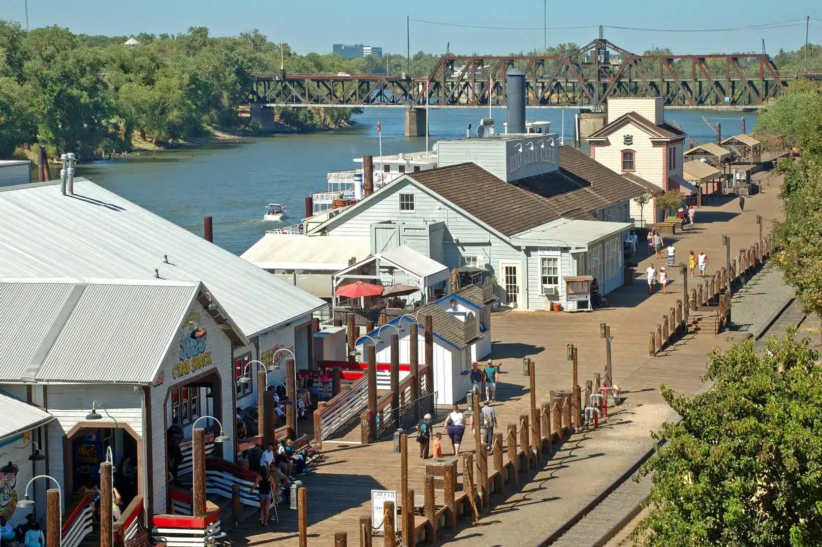 Historic Old Sacramento Waterfront boardwalk and shops along the river with people walking on a sunny day