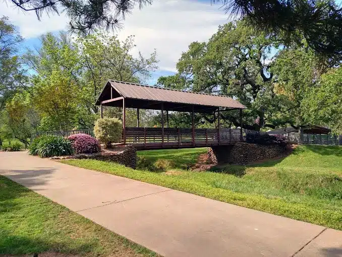 Covered bridge and flowers at Rusch Botanical Gardens in Citrus Heights, CA