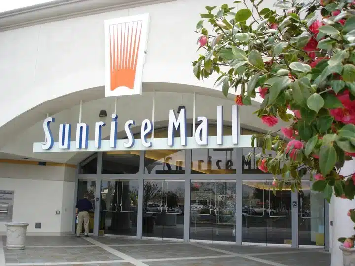 Main entrance of Sunrise Mall in Citrus Heights, CA with glass doors and flowered walkway